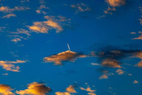 Aircraft contrails with red clouds, sunrise, Upper Austria