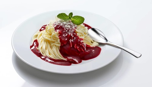 Spaghetti ice cream with hot raspberries on a white plate, decorated with a mint leaf, studio shot