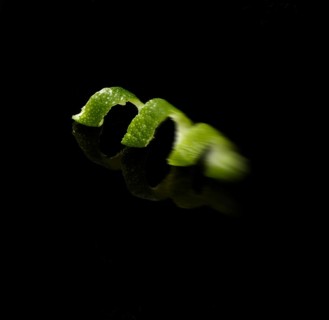 Lime zest against black background, motion blur, studio shot