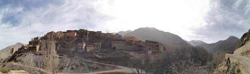 A small village on a hill surrounded by mountains under a sunny sky, panorama, Atlas Mountains,