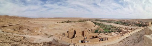 Historic buildings and an oasis in desert-like surroundings under cloudy skies, Morocco