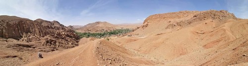 Extensive desert landscape with mountains and a small green oasis, Morocco