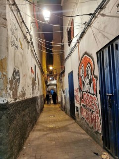 Narrow alley at night, illuminated with walls covered with graffiti and urban flair, Medina,