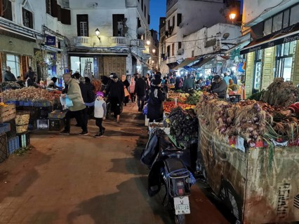 Close market in the Medina in the evening, lively with many people and stalls selling products,