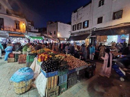 Hustle and bustle night market, lots of people and colorful stalls full of fresh produce in the
