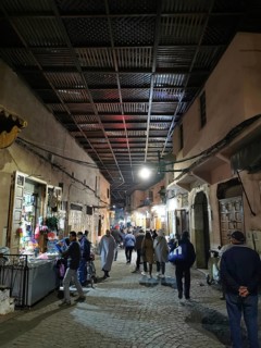 Bustling nocturnal alley in the Medina, with people under a covered path in an oriental market
