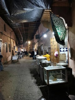Nocturnal market alley of an oriental medina with stalls and cozy lighting, Marrakech, Morocco