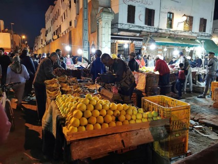 Colourful night market with numerous stalls, illuminated with the hustle and bustle of people in