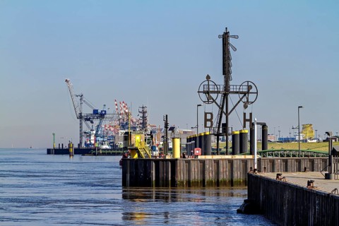 Industrial port with cranes and calm water under a blue sky, The City of Bremen