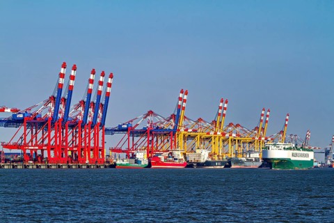 Various container cranes and ships at a busy seashore port, The cranes of the Bremen industrial