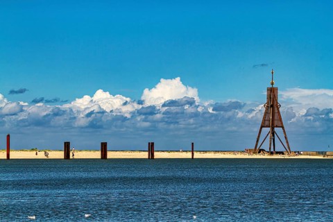 A quiet beach on the North Sea with blue skies, clouds and a lighthouse, Die Kugelbake von Cuxhaven