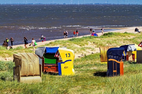 People on sandy beach with beach chairs on the coast and sea view, beach chairs on Cuxhaven beach