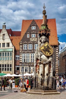 City center scene with the Roland statue in front of impressive half-timbered houses under a blue