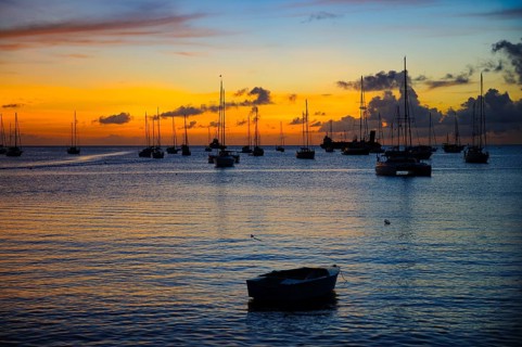 Romantic evening mood over Tyrrell Bay with many sailboats sailing yachts, rowing boat in the