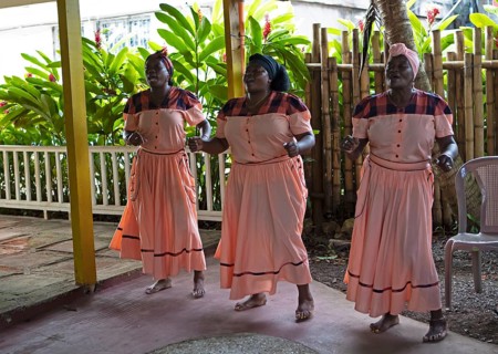 Guatemalan woman in traditional clothing singing and dancing, Garifuna people, Livingston, Izabal