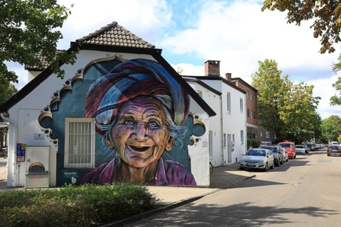 Graffiti portrait of an elderly woman from Bali. The work of art is part of the Kultur aus Tausch