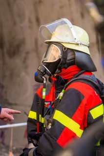Firefighter with respirator and helmet, focused and ready for rescue measures, fire brigade