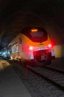 A train with glowing lights goes through a dark tunnel, fire department exercise at the Hermann