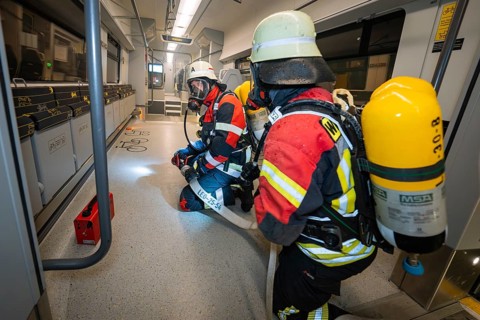 Firefighters inspect the interior of a train in full gear, fire brigade exercise on the Hermann