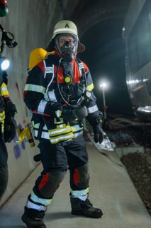 A firefighter in full protective clothing with respirator in the tunnel, fire department exercise