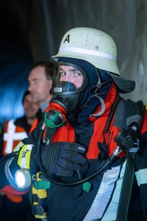 Close-up of a firefighter wearing respiratory mask and protective clothing in a tunnel, fire
