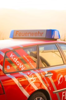 Red fire engine with blue signal light at dusk, fire department exercise on the Hermann Hesse