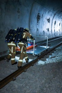 Firefighters push a stretcher on the train tracks in the tunnel, fire department exercise on the