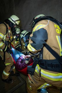 Firefighters free a person in a tunnel with a stretcher, fire brigade exercise on the Hermann Hesse