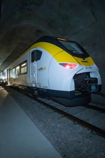 A train with yellow and white colors stands in the tunnel at night, fire department exercise on the