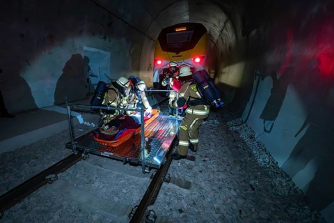 Firefighters work in an illuminated tunnel during a rescue operation, fire brigade exercise on the