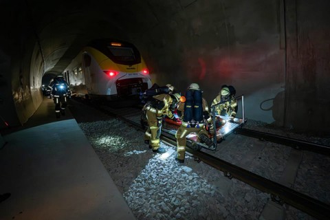 Firefighters rescue a person on the tracks in a tunnel at night, fire brigade exercise on the