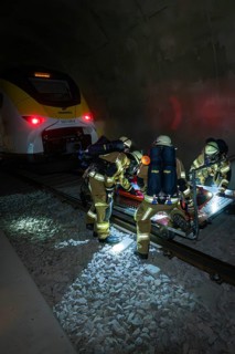 Firefighters carry out a rescue operation next to a train in a tunnel, fire brigade exercise on the
