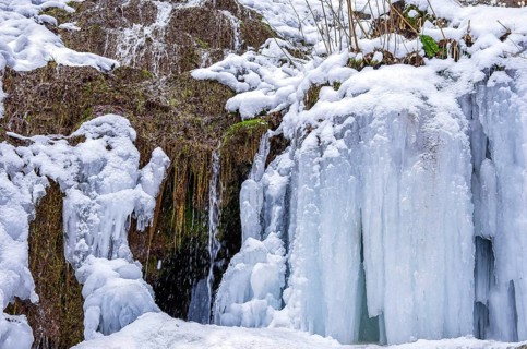 Urach waterfall full of bizarre ice formations frozen at winter temperatures, Bad Urach, Swabian