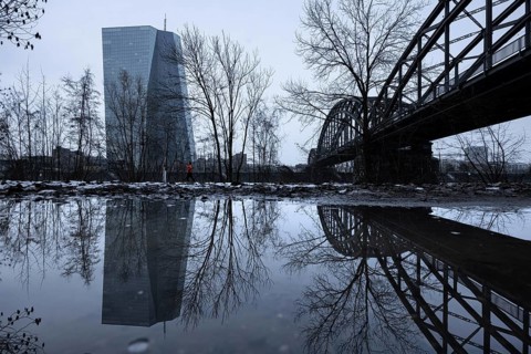 The European Central Bank (ECB) in Frankfurt is reflected in a puddle on the banks of the Main,
