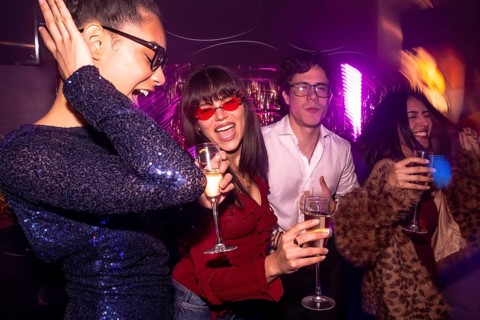 Group of diverse friends celebrating a special occasion, drinking champagne, dancing and having fun