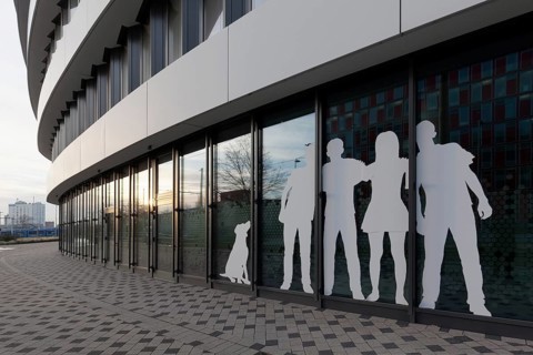 Paper cut family with dog, sticker on window front of an office building, Medienhafen Düsseldorf,