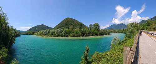 Panoramic view of lake with surrounding mountains and road on the edge, Slovenia