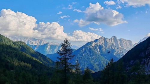 Wide mountain landscape under cloudy sky with forest cover, Slovenia