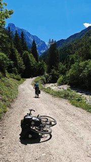 A bike is lying on a bike path surrounded by forests and mountains, Slovenia