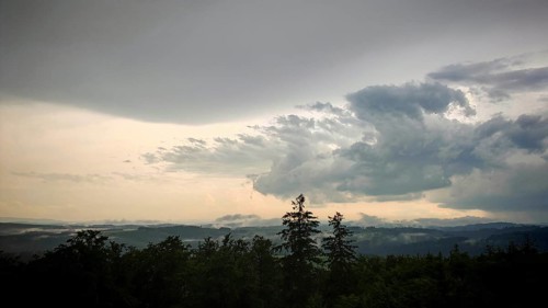 Massive clouds pile up over a green, wooded landscape, Fichtelgebirge