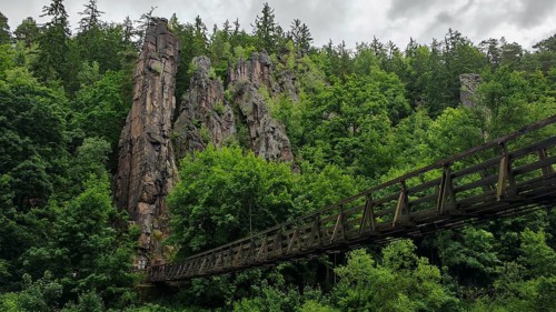 Suspension bridge leads across a river through wooded rocks, Hans Heiling Rocks, Eger Valley, Czech