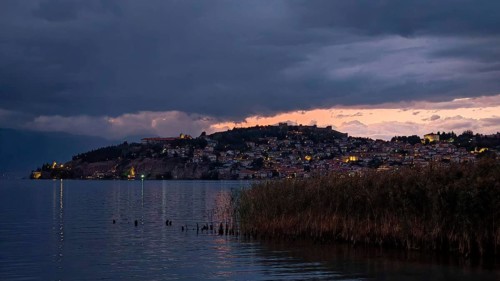 Night scene of an illuminated lake with a city in the background, Lake Ohrid, North Macedonia