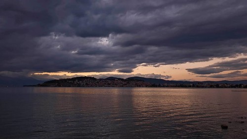View of a lake at sunset with dramatic clouds covering the sky, Lake Ohrid, North Macedonia