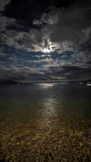 A nighttime lake panorama with reflecting moonlight and dramatic clouds in the sky, Lake Ohrid,