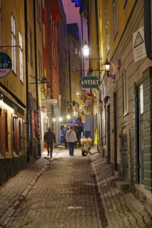 A picturesque alley at dusk with cobblestones and warmly lit historic buildings, Gamla Stan,