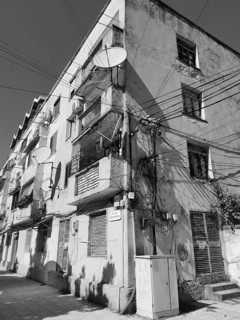 Wired old façade equipped with satellite dishes in the city, Albania