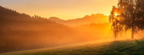 View of the Wartburg in the Thuringian Forest at sunrise and morning fog, the sun shining through
