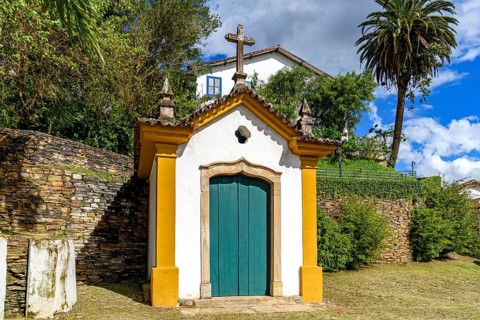 Historic 18th century chapel with a stone crucifix. Passo da Ponte Seca in the city of Ouro Preto