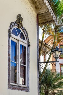 Old window decorated with a sculpture of a face and other ornaments in a historic house in the city