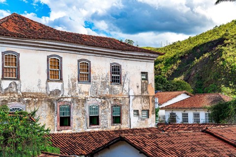 Facade of a historic colonial mansion deteriorated by time in the city of Ouro Preto in Minas